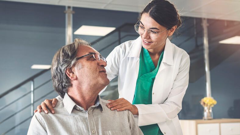 A patient concierge talking to a patient after medical office specialist training