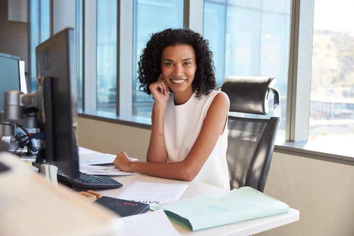 A smiling female medical office specialist in an office after completing her medical office specialist training
