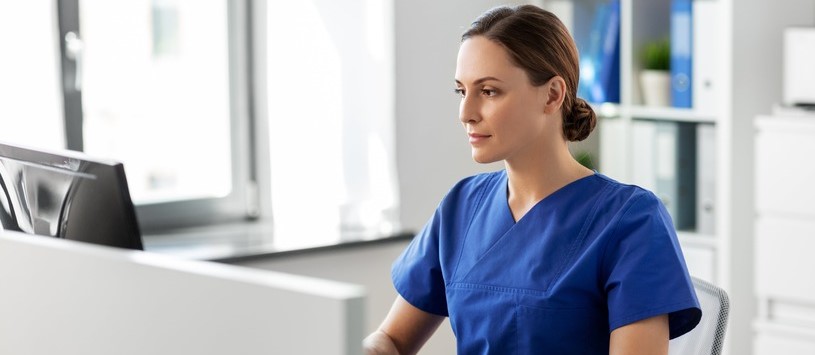 Medical Billing & Administrative Specialist working on a desktop computer.